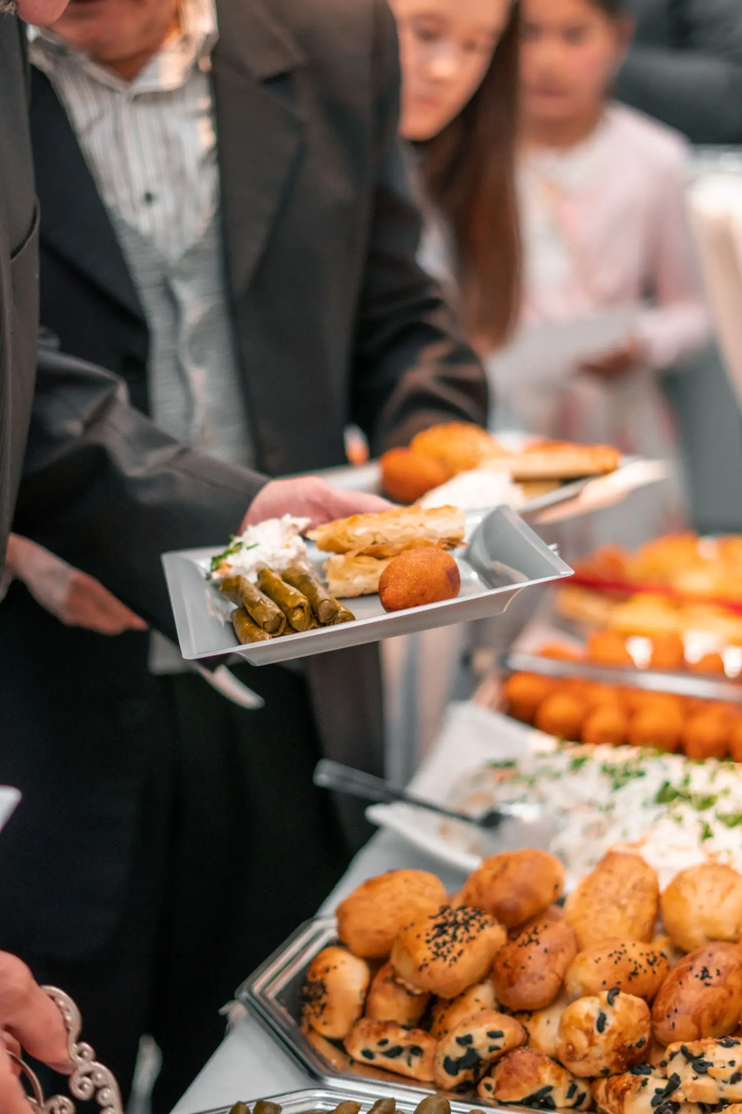 Vendégek válogatnak catering falatokból