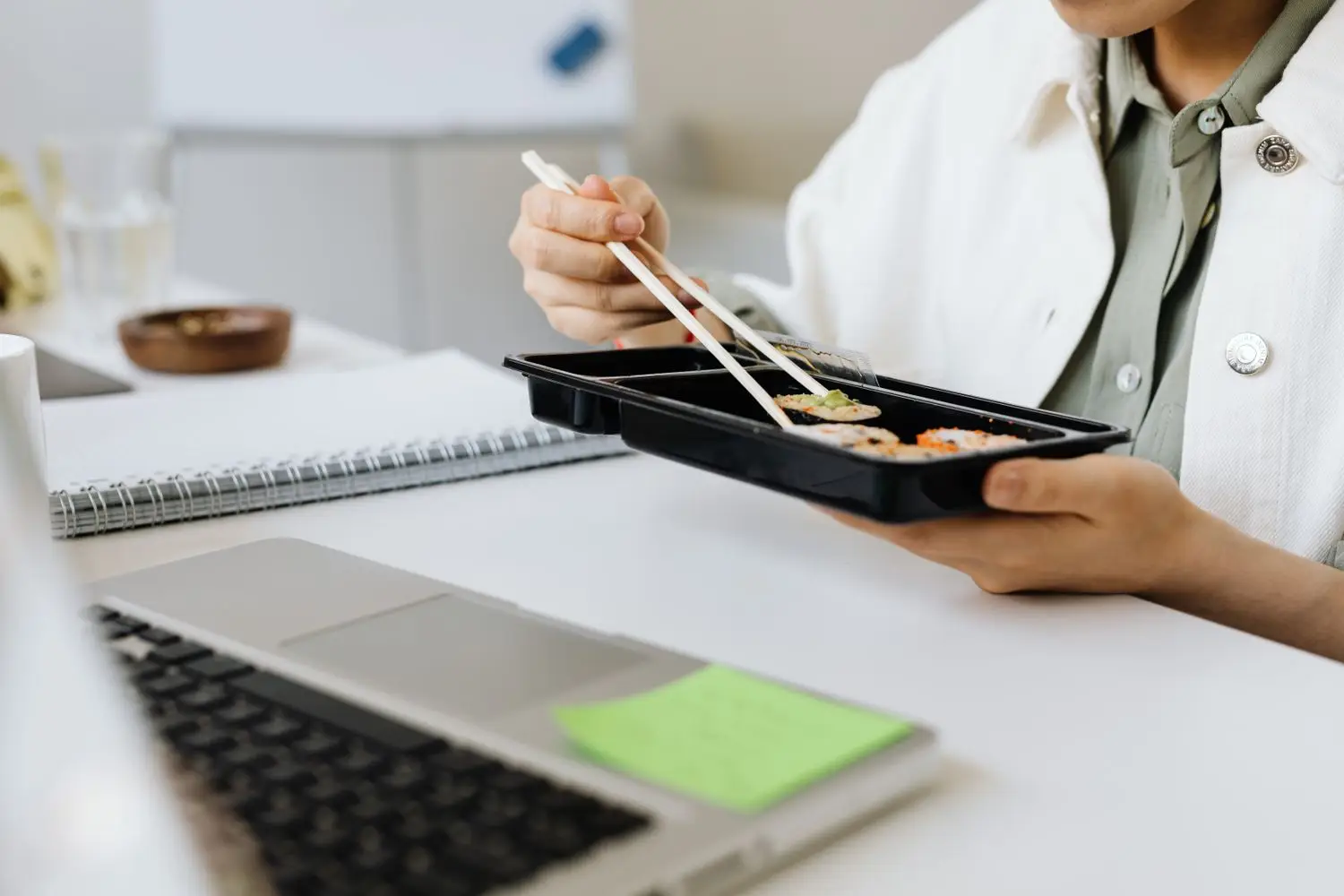 Irodai munkatárs ételrendelést egyeztet laptop mellett